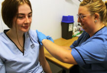 A member of staff gets their vaccine