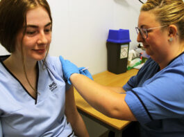 A member of staff gets their vaccine